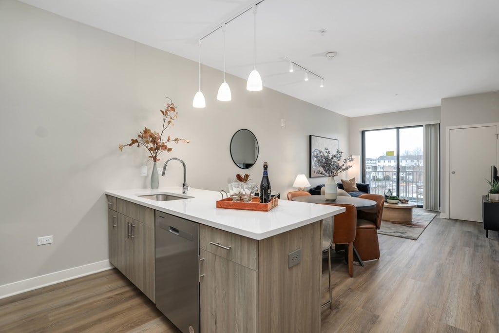 a kitchen with an island and a living room with a couch at Beekman on Broadway, Ann Arbor, MI, 48105